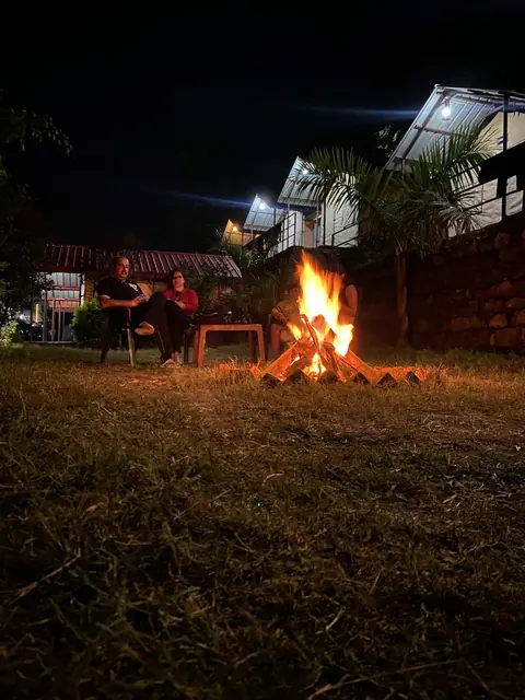 Guests sit around the evening bonfire at the camp