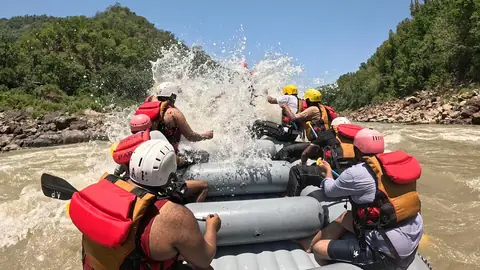 A big splash of white water hits the crew in the middle of a rapid